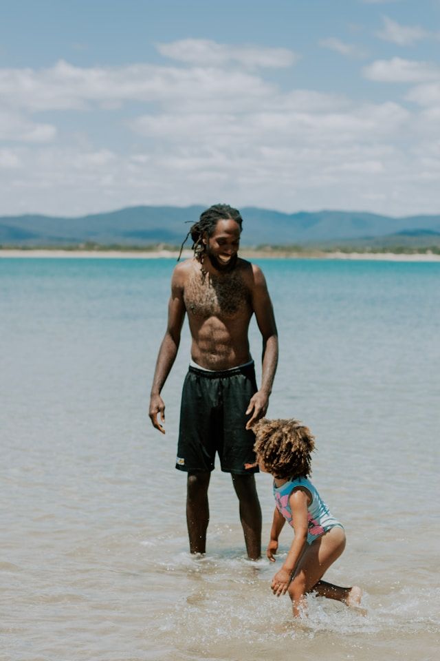 Father and daughter play at a beach