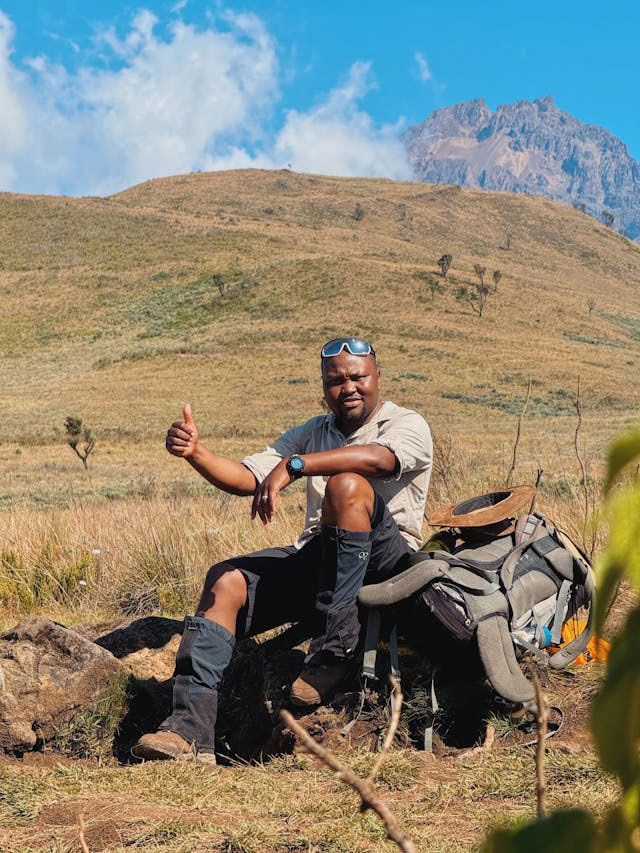 A hiker rests while climbing Mount Kilimanjaro
