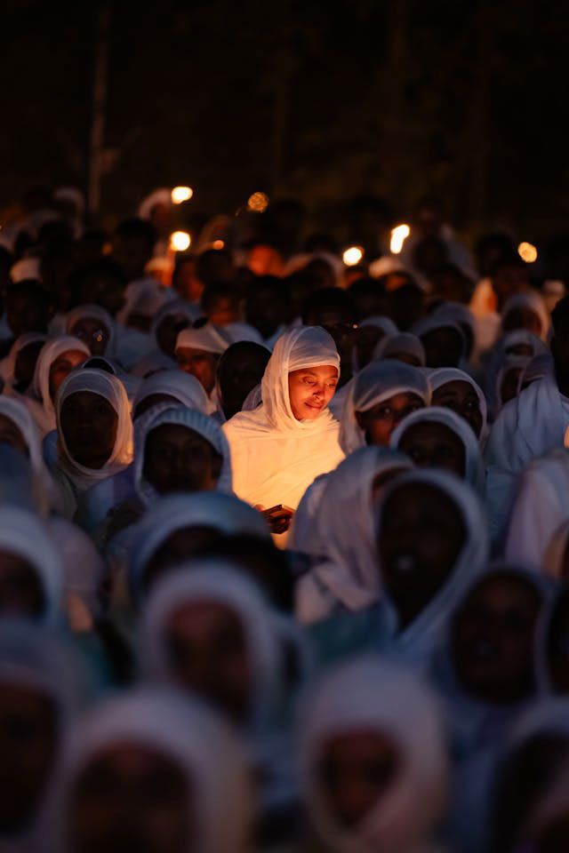 A woman during a candlelit prayer, cultural festival in Addis Ababa.