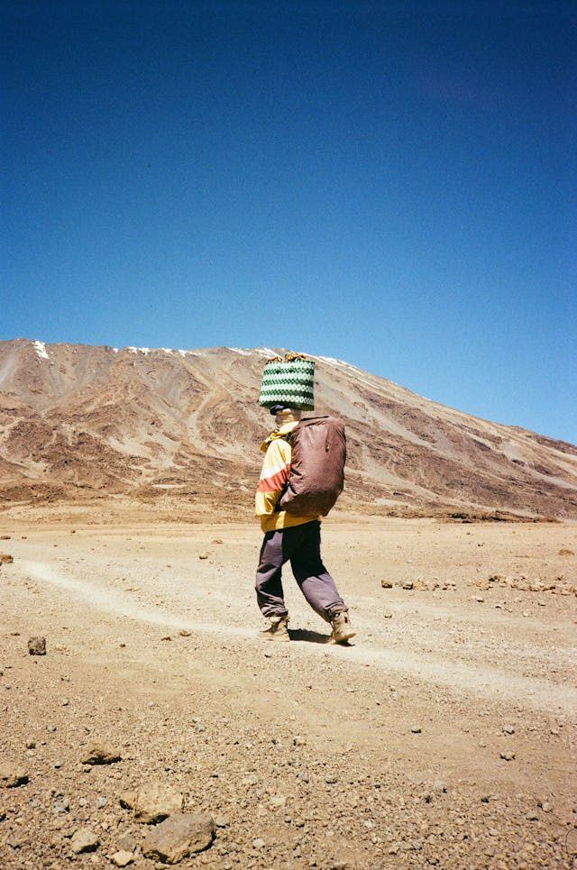 A porter carries luggage up Mount Kilimanjaro